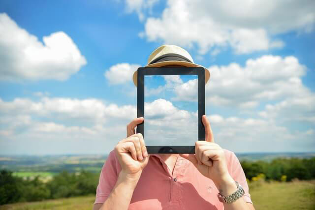 man holding tablet with a cloud background