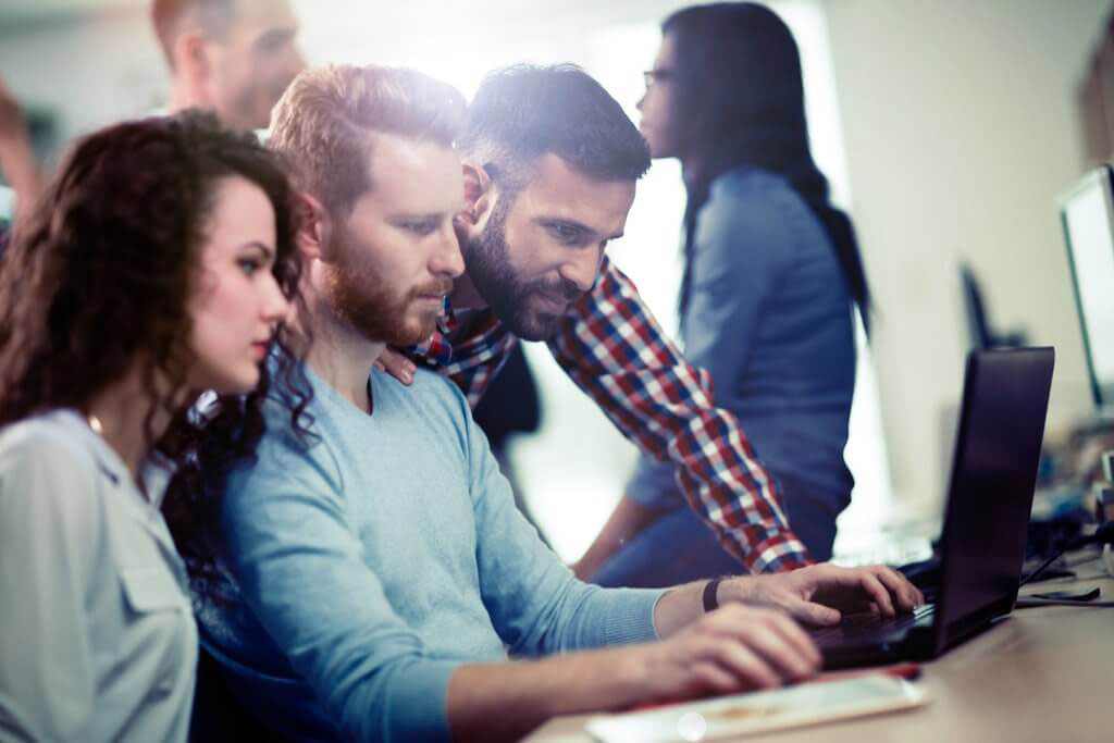 three people looking at a computer.