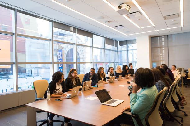 a group of business people sitting at a conference table.