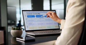 A woman working on a laptop creating a customer journey map.
